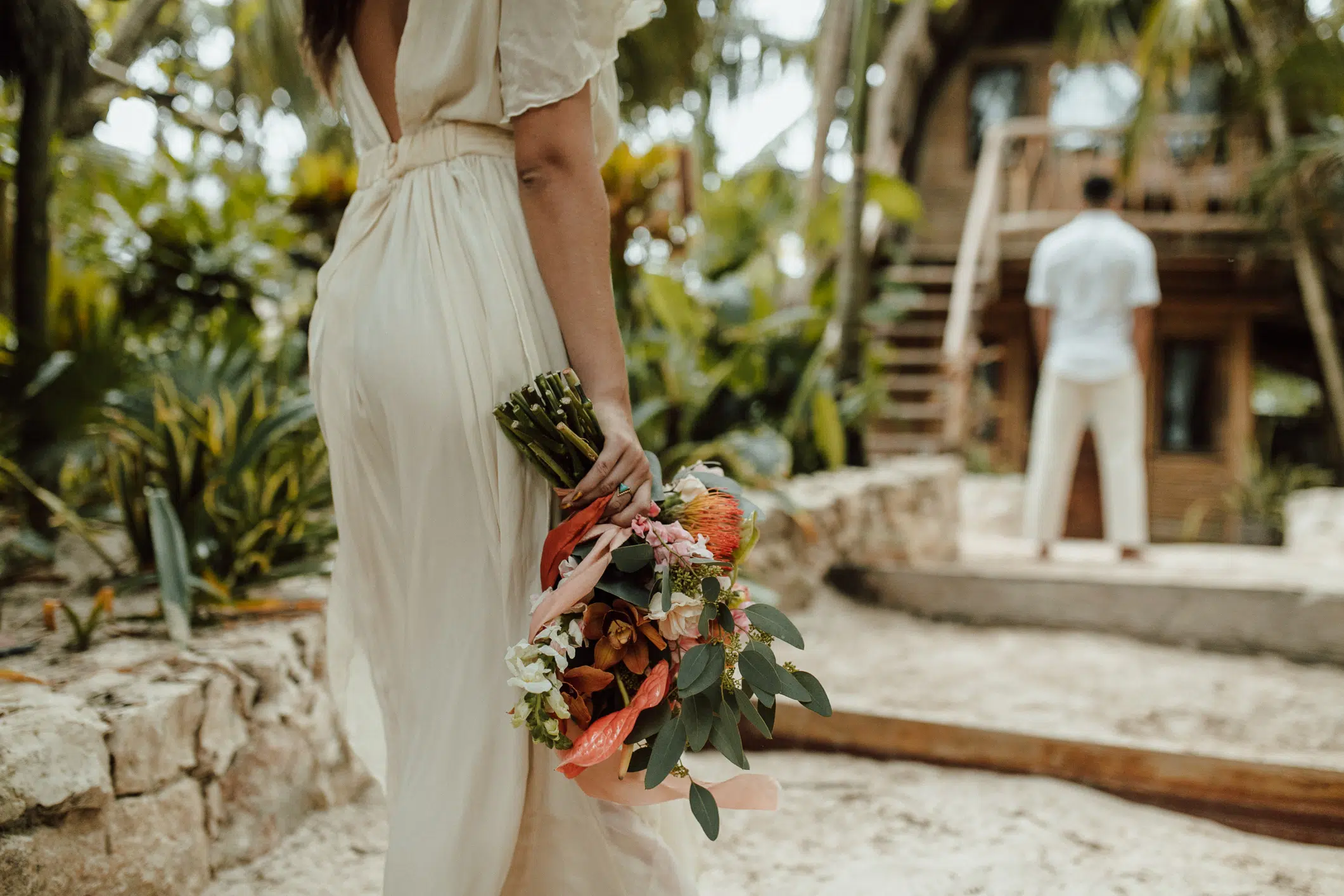 Bride holding a tropical bouquet in the jungle garden